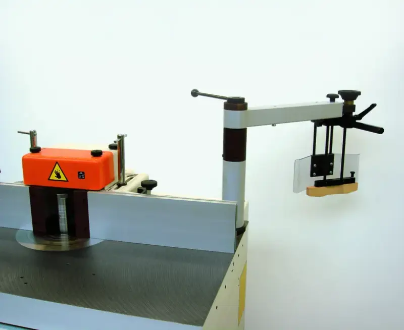 Schwenkvorrichtung Fuss a=80mm (Standard), mit orangefarbener Schutzhaube, Einstellrädchen und seitlichem Schutzarm auf Weiss.