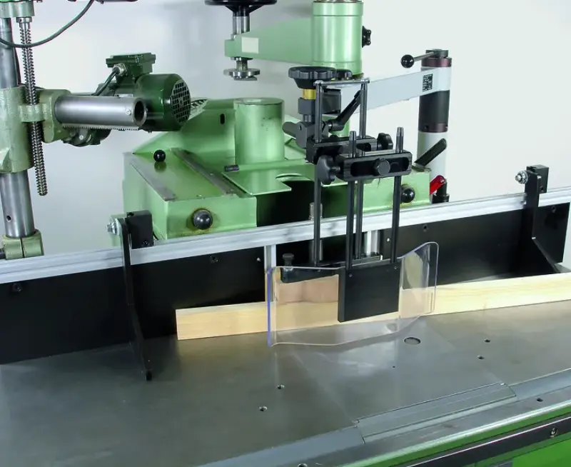 Die Schwenkvorrichtung mit Fusss a=80 mm (Standardausführung) ist eine grüne Holzbearbeitungsmaschine mit Schutzhaube.