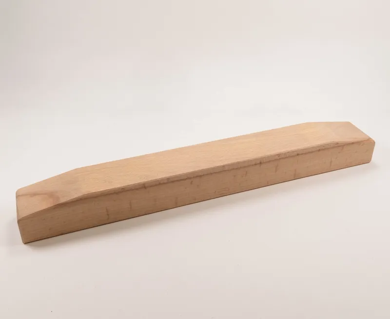 Ein rechteckiges Hilfsholz ohne Besschlaege zur Seitendruckvorrichtung mit abgeschraegten Enden auf weissem Hintergrund.