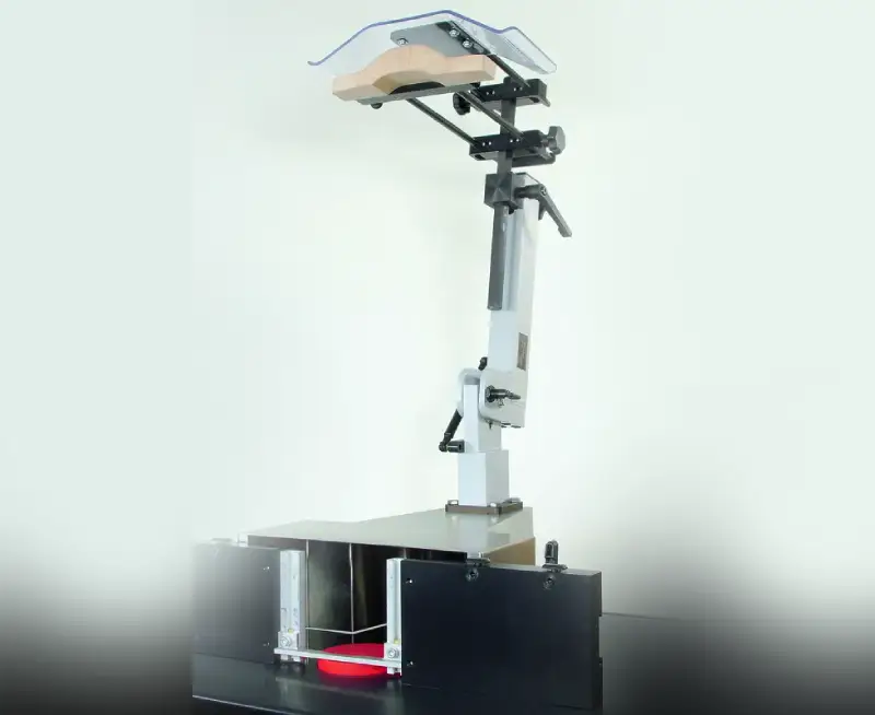 Die Schutz- und Druckvorrichtung 24171 mit Roboterarm, Klappmechanismus und Unterbau für Arbeitsschutz auf schwarzer Plattform.