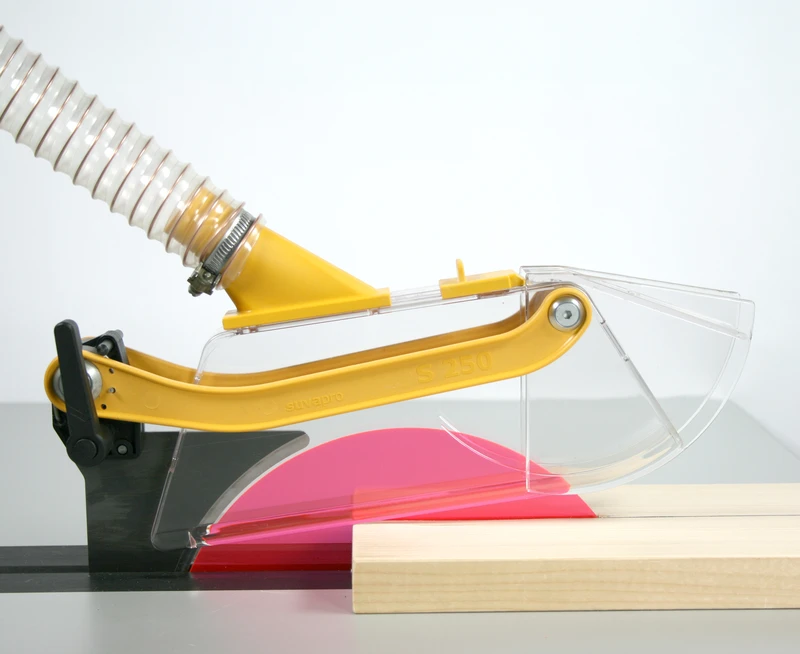 Schutz- und Absaughaube S 250 deckt Kreissaegeblatt beim Schneiden von Holz, mit Staubabsaugung, am Tischsaege-Arbeitsplatz.