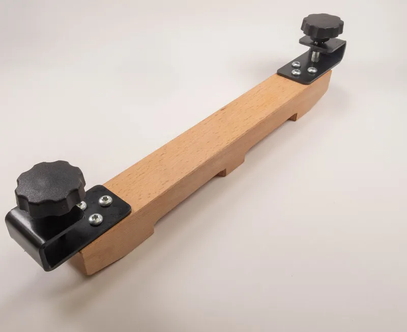 Das Hilfsholz mit Beschlägen für Schutzvorrichtung (561) hält Werkstücke mit Kunststoffknöpfen, Metallwinkeln und Schrauben sicher.