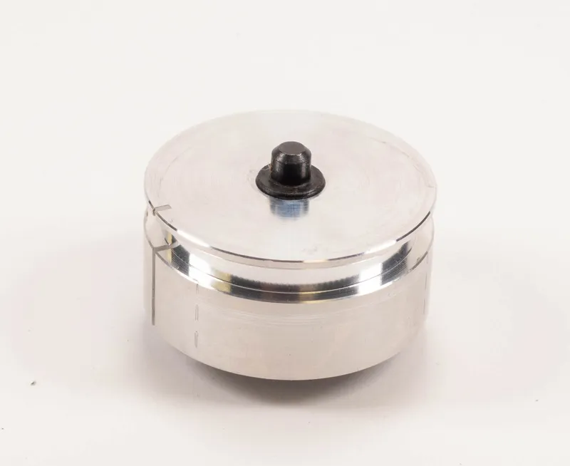 Runde silberne Seiltrommel ohne Drahtseil (Gewichtsentlastung, Typ 811) mit schwarzem Knopf auf weissem Hintergrund.