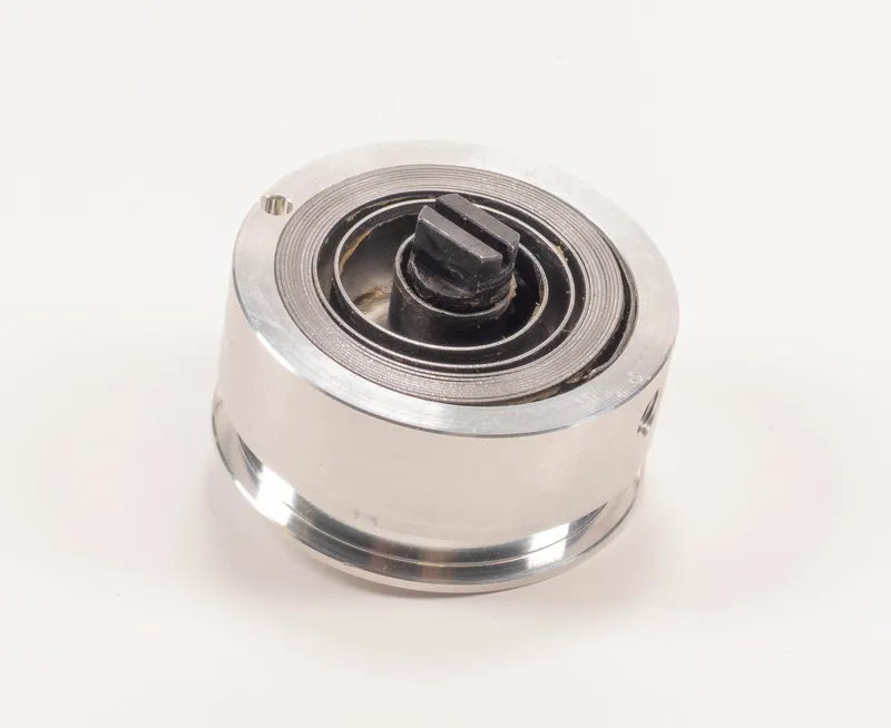 Zylindrische Seiltrommel 811 ohne Drahtseil mit rotierender Achse und Rillen für Gewichtsentlastung, vor weissem Hintergrund.