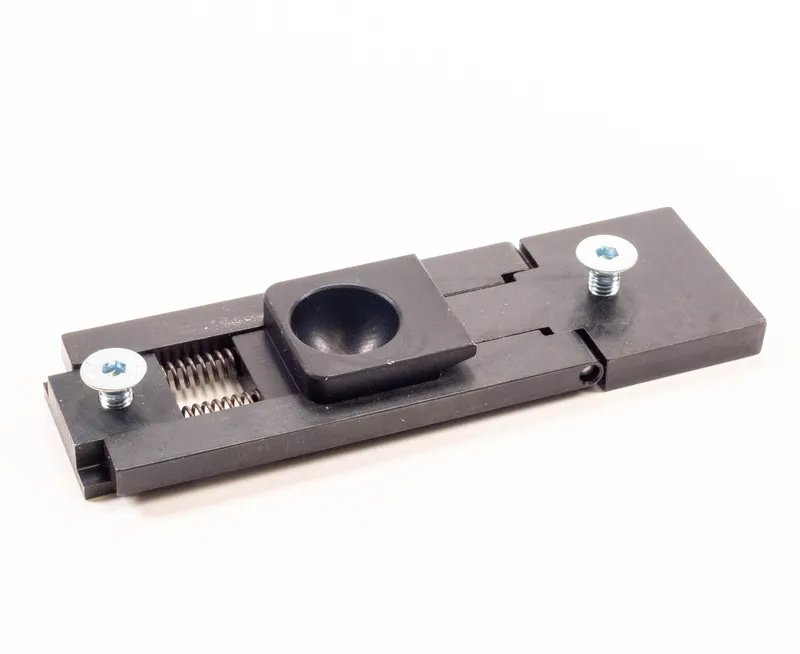 Scharnier (826), schwarzer Kunststoff-Gleitwagen mit Mulde, 2 Schrauben, sichtbarer Feder, integriertem Gelenk für Montage.