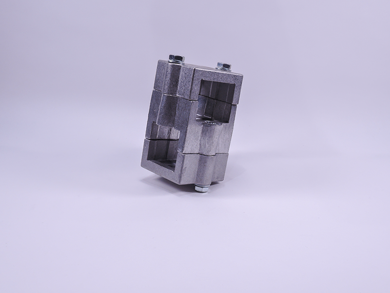 Ein metallisches, geometrisches Kreuzklemmstück 846 mit Aussparungen steht auf hellem Lila, oben und unten mit Bolzen fixiert.