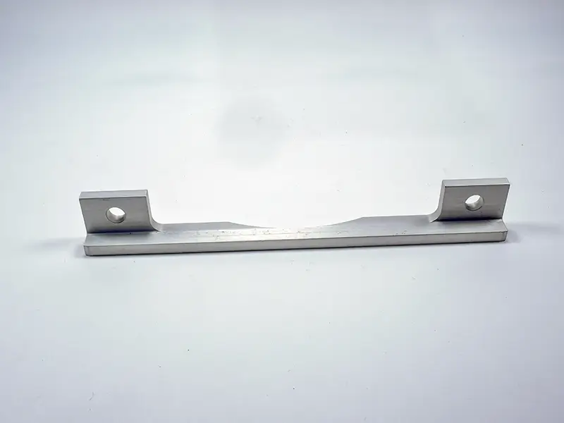 Ein Anschlaglineal aus Metall mit den Maßen 195 × 6 mm (8803) liegt auf weißem Hintergrund, mit zwei angehobenen Enden und einem Rundloch.
