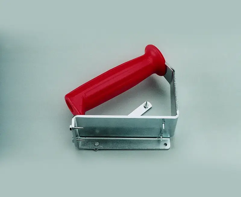 Handgriff links 9337: Metallwerkzeug mit rotem Griff, Zahnung und verstellbarer Schraube für Teppich- oder Linoleumschnitt.