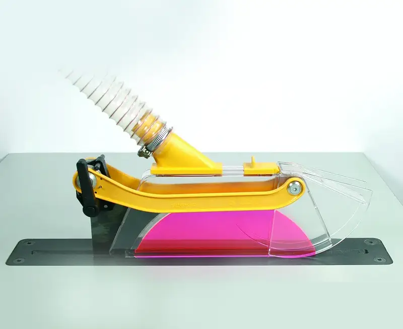 Die Schutz- und Absaughaube S 250 (33717) für Sägeblatt Ø150-250 mm mit Spiralschlauch über Behälter mit pinker Flüssigkeit.