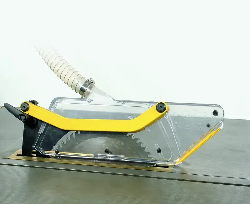 Schutz- und Absaughaube S 315 mit Absaugschlauch, transparenter Abdeckung, gelbem Griff auf glattem Werktisch montiert.