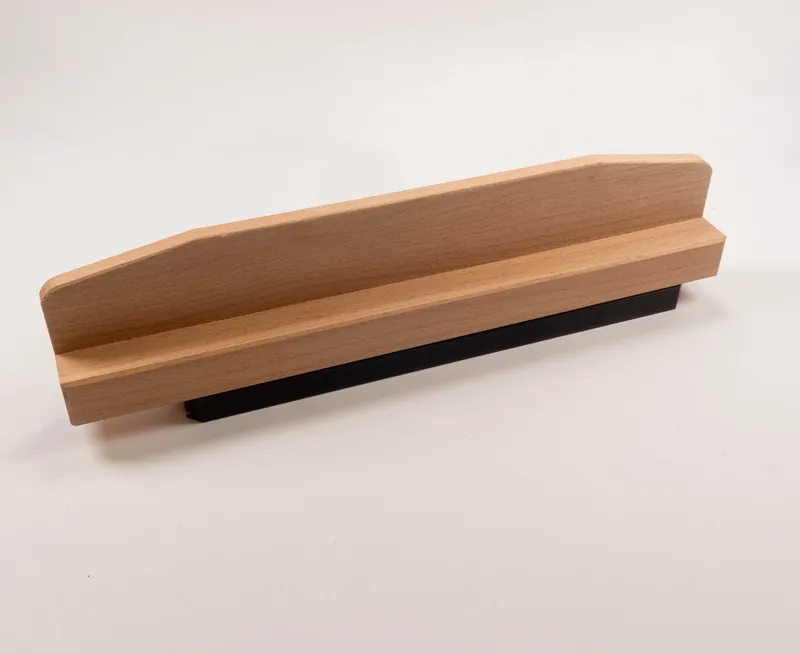 Druckschuh mit schmaler Auflage (558) aus Holz, flacher Griff, schwarze Kante, als Werkzeugsicherung auf weissem Untergrund.