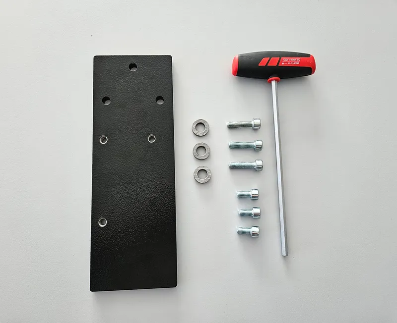 Schwarze Metall-Montageplatte, vier Silber-Schrauben, vier Unterlagsscheiben, T-Griff-Inbusschlüssel für Maschinenschutz.