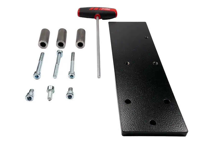 Schwarze Metallplatte, T-Griff-Inbusschlüssel, Abstandshalter und Schrauben für das Suvamatic-Set 14426 sind übersichtlich angeordnet.